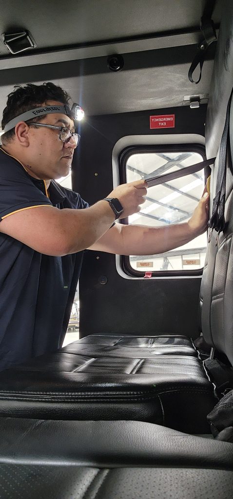 Technician from Skyshine Ltd detailing the interior of an aircraft with precision, wearing a headlamp for enhanced visibility.